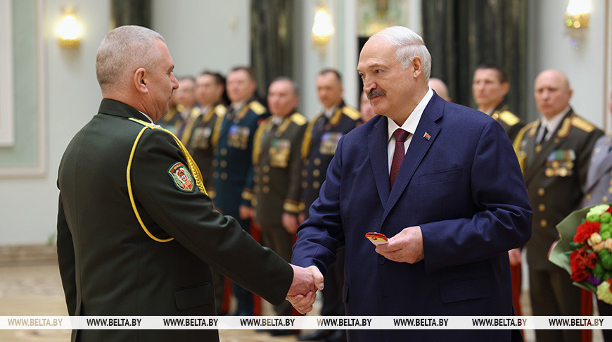 Belarusian President Aleksandr Lukashenko presents the Major General shoulder straps to Andrei Filatov