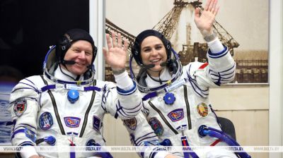 Members of the 21st visiting expedition to the ISS check spacesuits